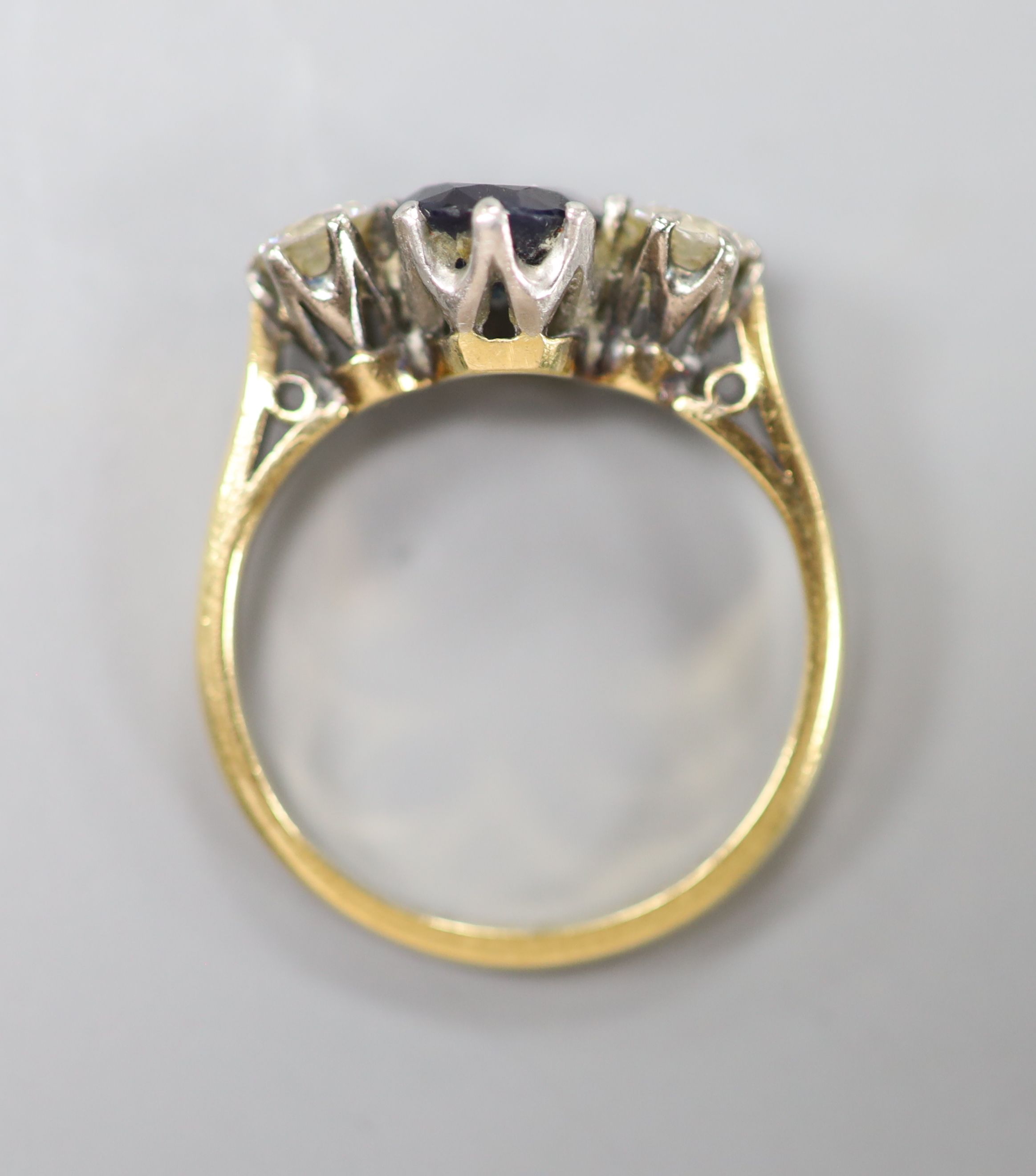 A sapphire and diamond three-stone ring, 18ct gold and platinum setting, size K, gross 3.3 grams.